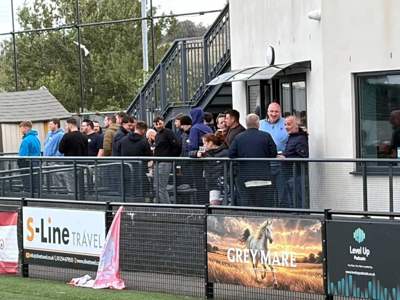 Supporters with drinks on the terrace outside the Legends Sports Bar