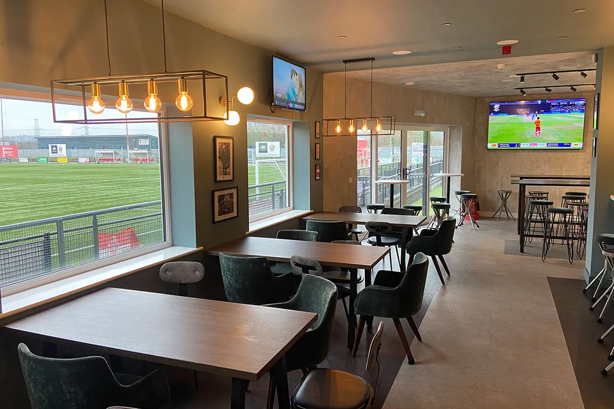 Seating and big screens inside the Legends Sports Bar, overlooking the pitch